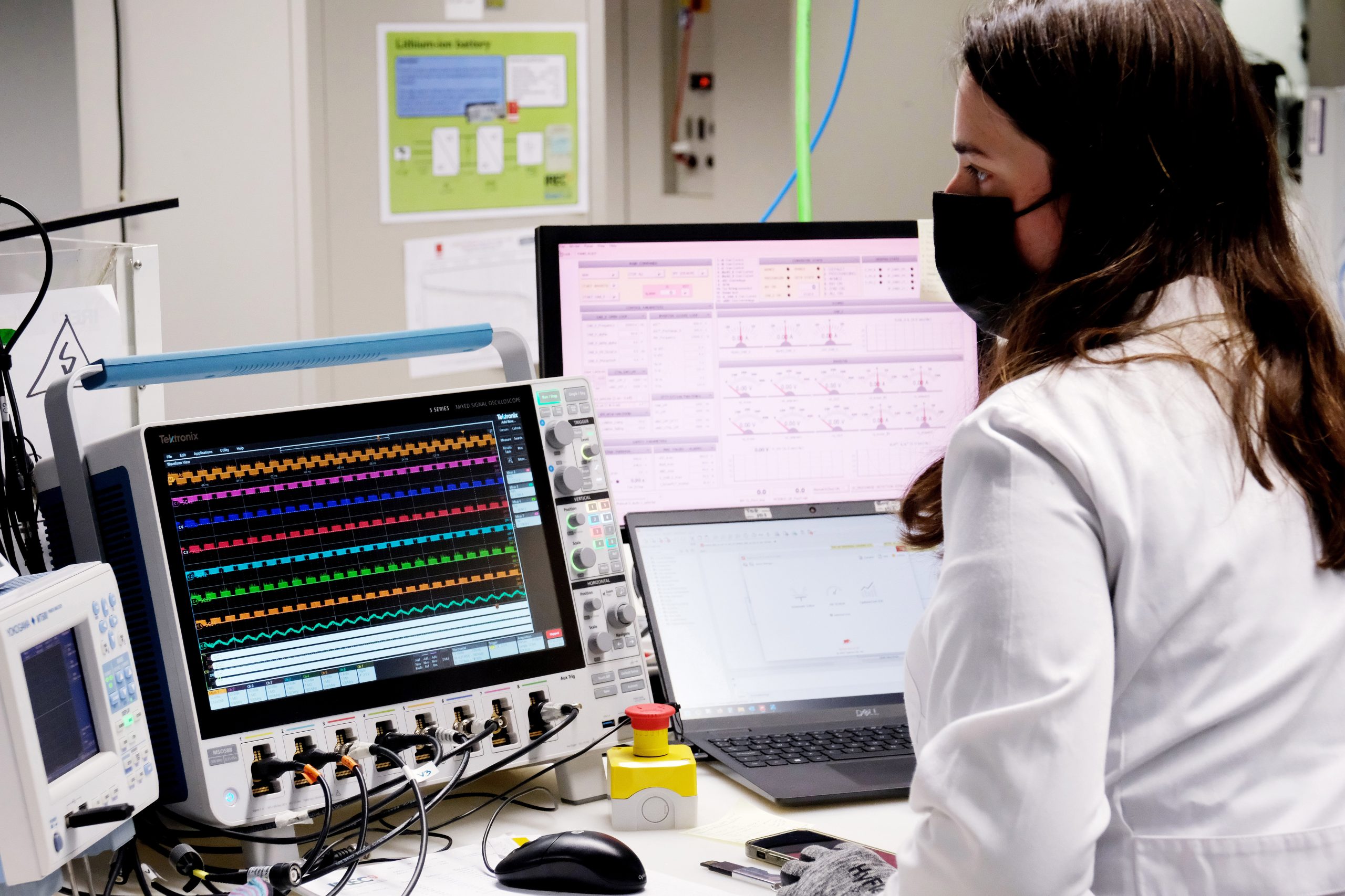 Scientist working with computers and an oscilloscope in a laboratory, representing research on energy systems, market modelling, regulation and socio-economic analysis of sustainable energy technologies.