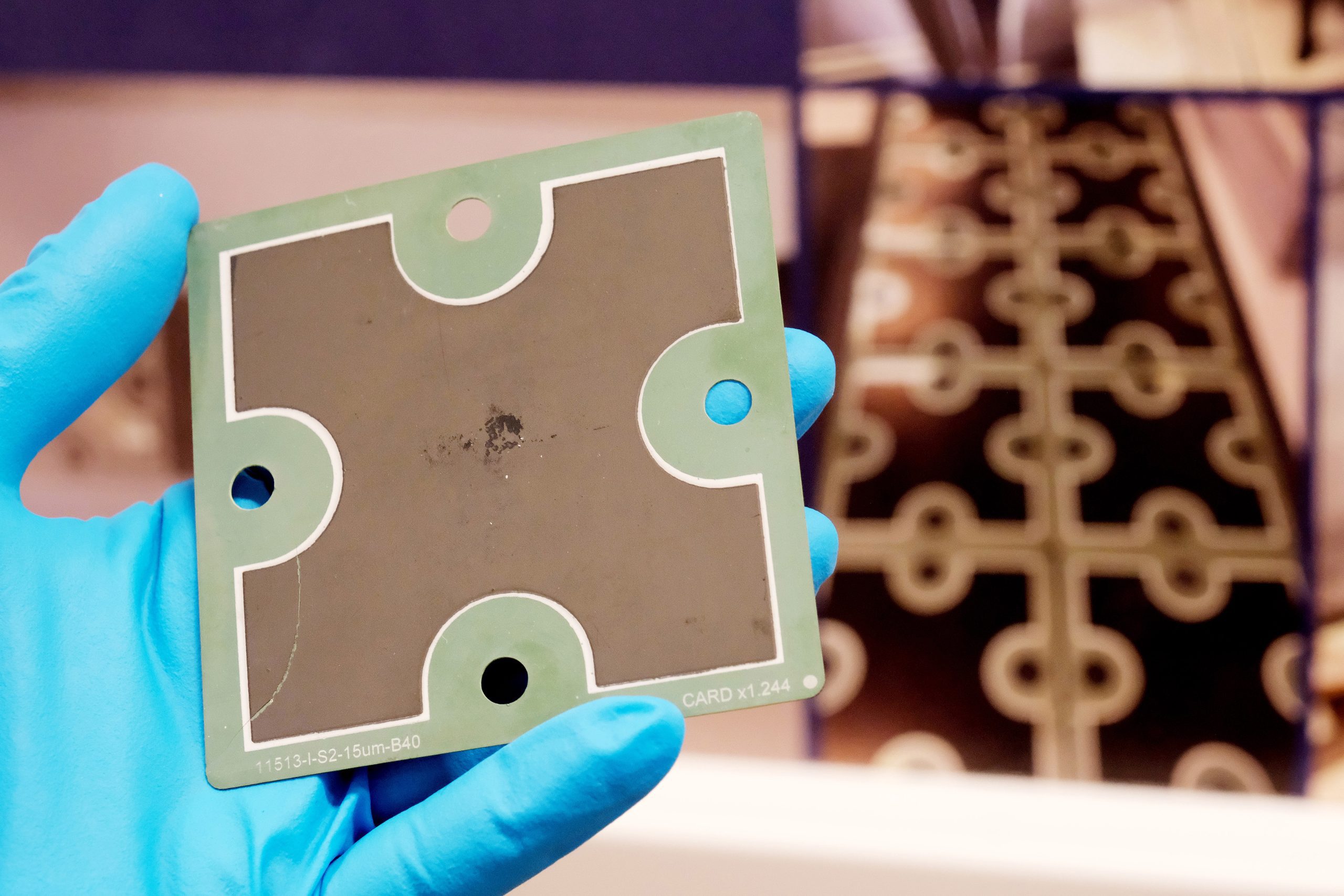 Electronic research component card with four perforations used in iontronic and neuromorphic device development, supporting low-power edge computing and silicon-compatible smart sensing systems.