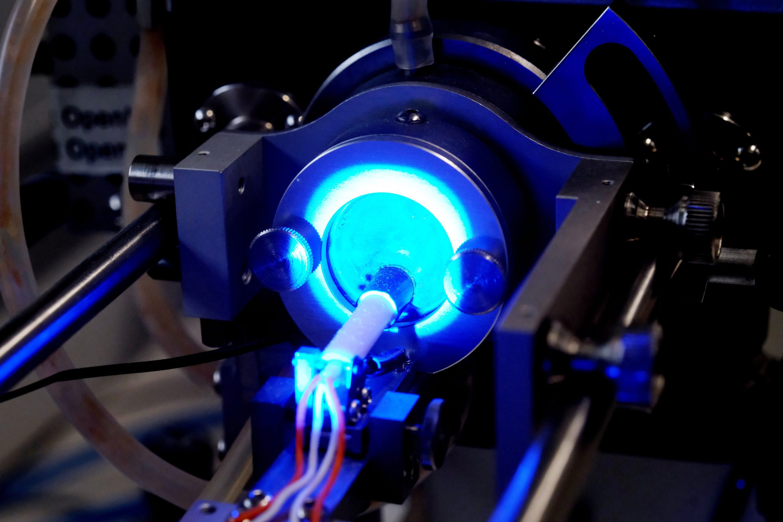 Scientific laboratory process illuminated by blue light during experimental analysis of advanced materials and electronic devices for energy and neuromorphic research applications.