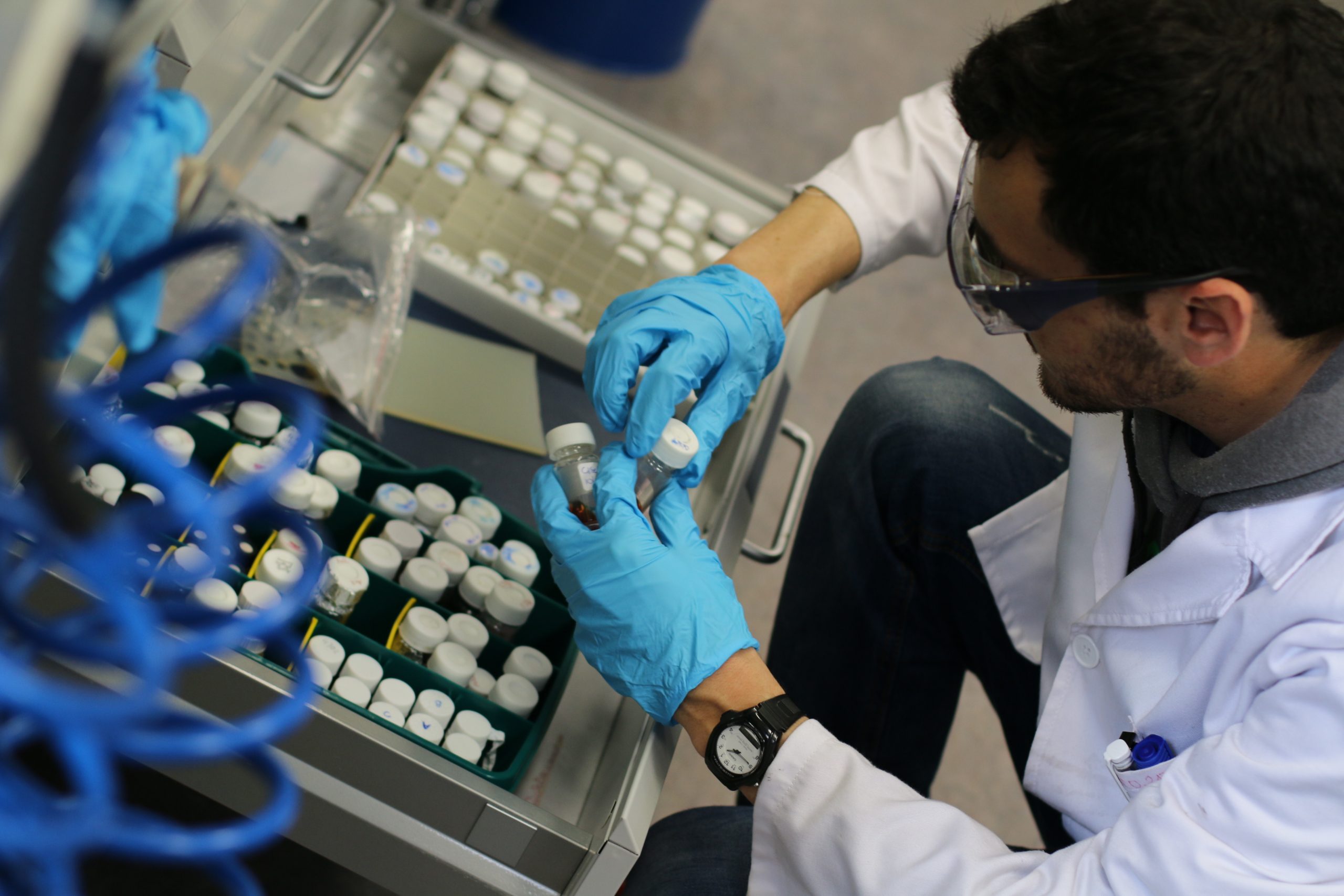 Scientist handling and storing small laboratory vials, representing electrocatalyst development and experimental workflows for biomass conversion and hydrogen production research