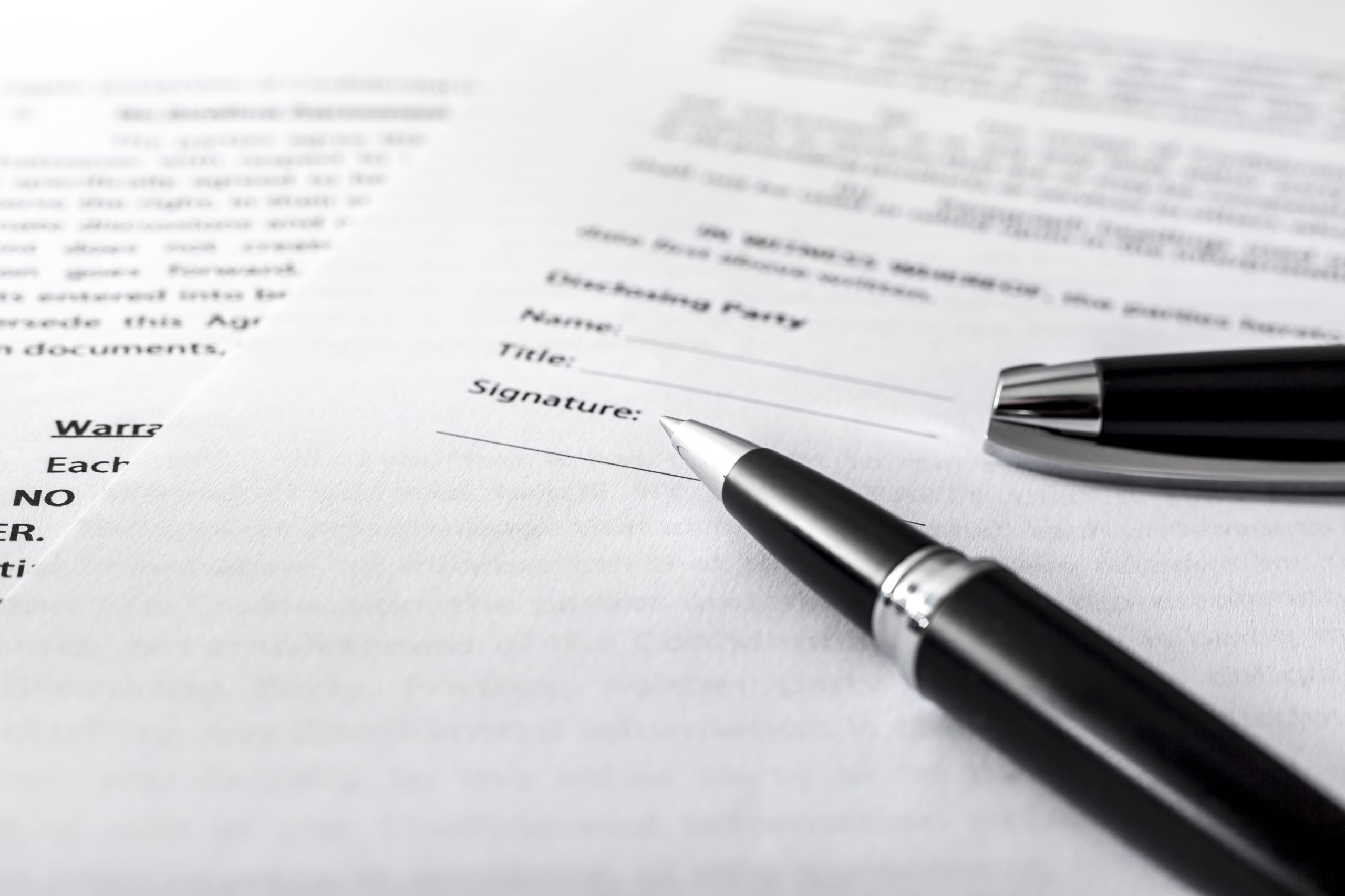 Close-up of a signed contract, representing IREC's commitment to legal compliance, transparency, and public administration coordination.