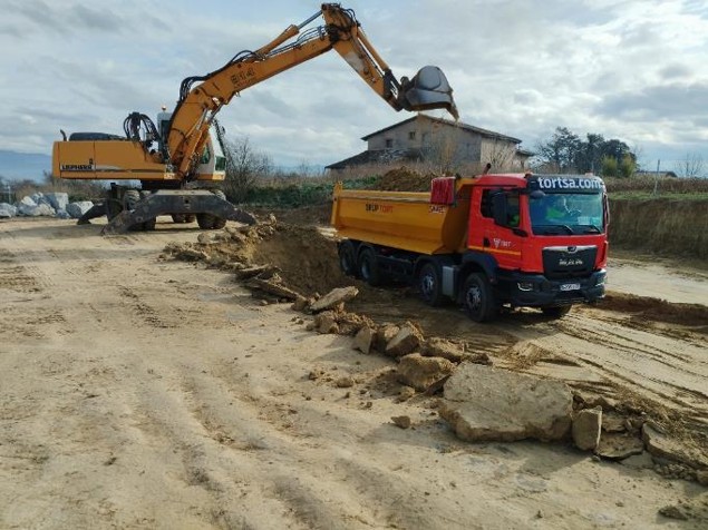 Excavator loading soil into a truck at a construction site