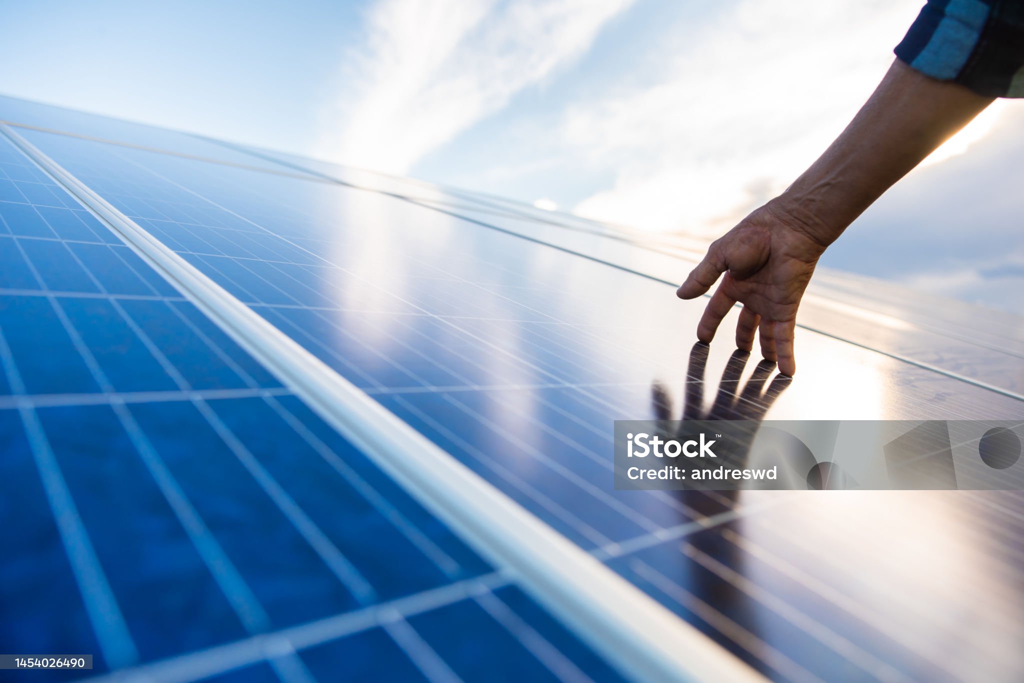Working man's hand touching a solar panel